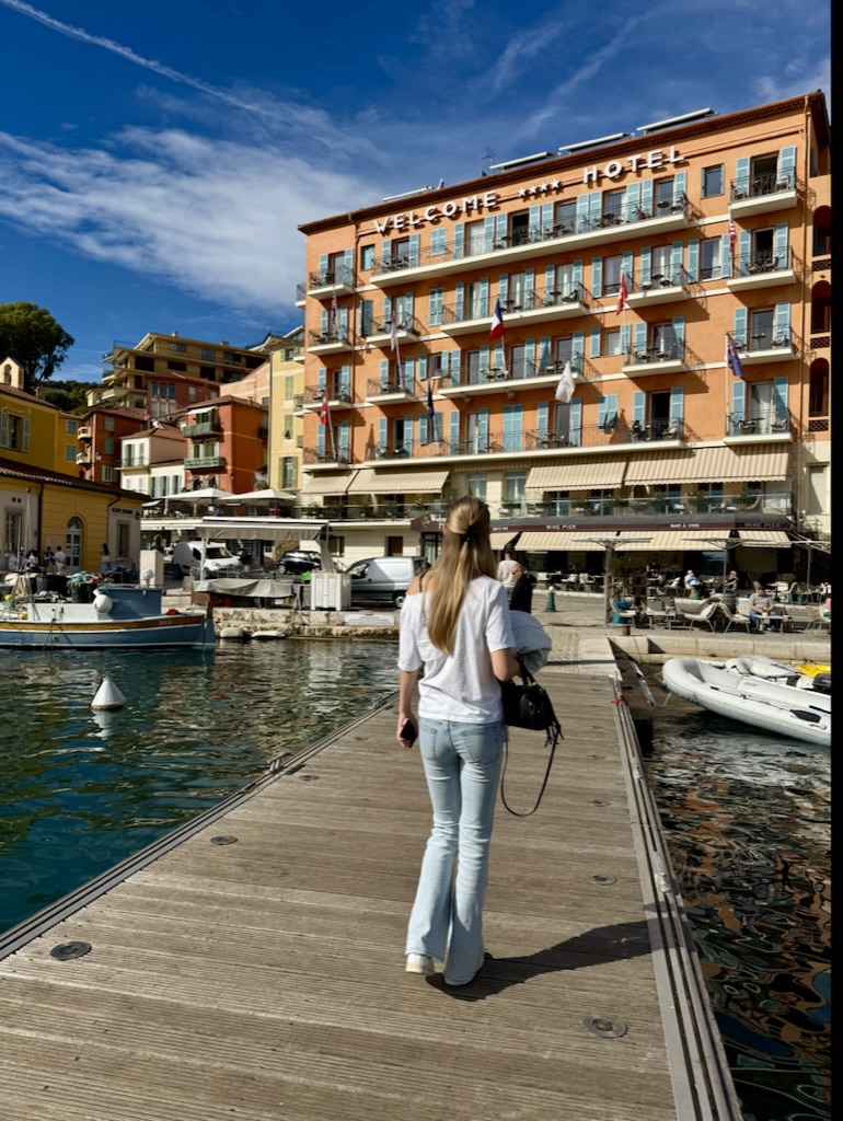 Welcome Hotel med ljusblå fönsterluckor och balkonger med utsikt över vattnet