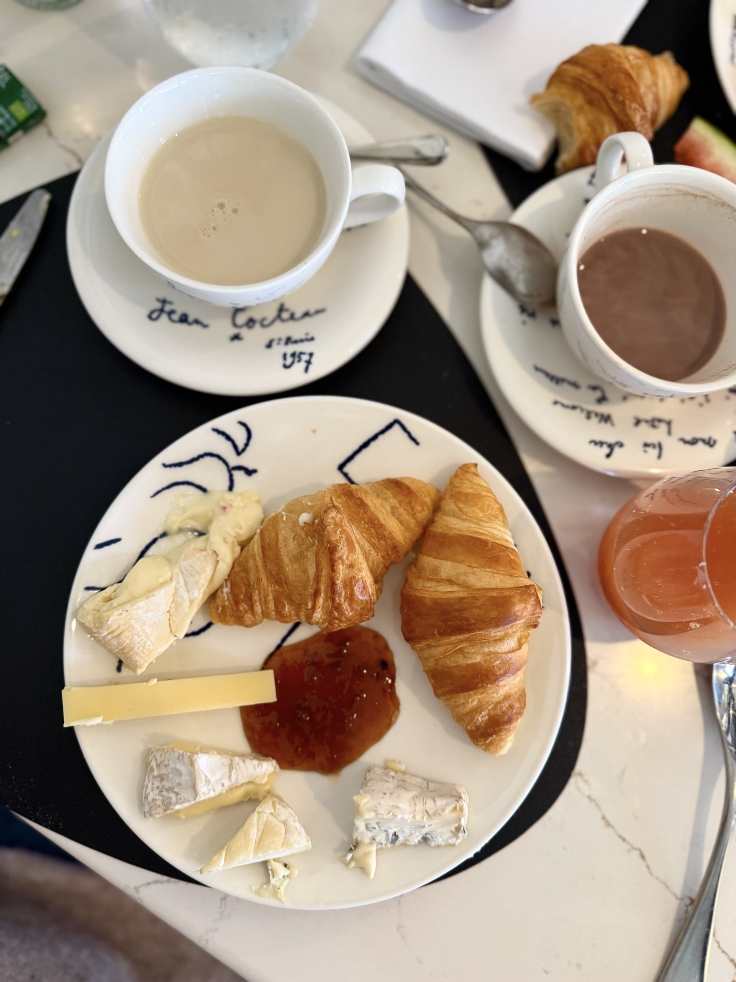 Fransk frukost med dessertostar, marmelad och croissanter